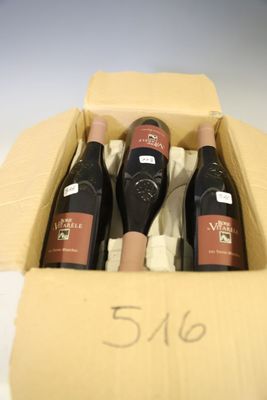 three bottles of wine in a cardboard box on a table