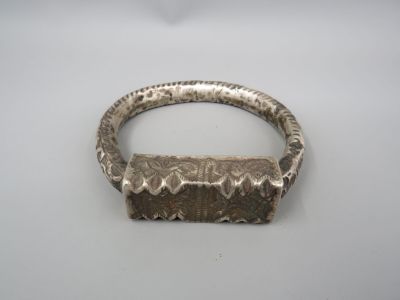 gros plan d'un bracelet en argent sur une surface blanche