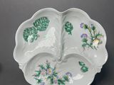 two plates with flowers and leaves on them on a table