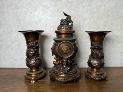 trois vases en bronze posés sur une table en bois