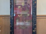 une armoire haute ornée d'un tableau, dans une pièce