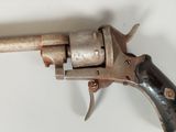 an old gun with a wooden handle on a white surface