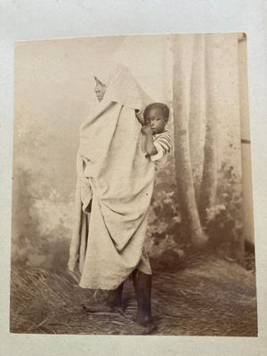 an old black and white photo of a child wrapped up in a blanket
