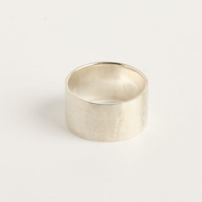 gros plan d'une bague en argent sur une surface blanche