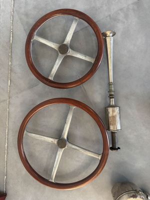 two wooden steering wheels on the floor next to a pair of shoes