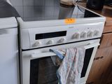 a white stove top oven sitting in a kitchen next to a dishwasher
