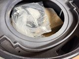 a plastic bag in the top of a black trash can