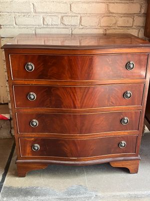 a wooden chest of drawers on display in a room