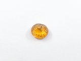 a close up of a yellow sapphire stone on a white surface