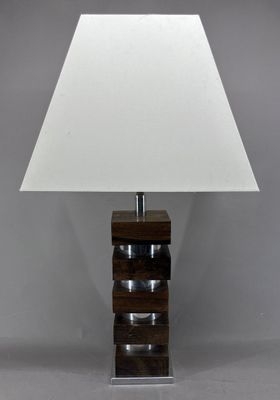 une lampe de table en bois surmontée d'un abat-jour blanc
