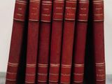 several red books stacked on top of each other on a table