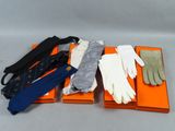 trois paires de gants et une cravate dans une boîte posée sur une table