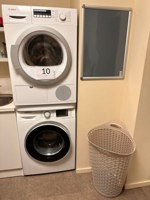 two washers and a dryer in a small room