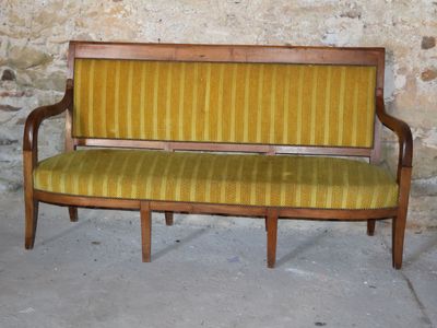 a wooden bench with a yellow striped upholstered seat