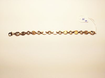 a close up of a gold bracelet with a chain attached to it