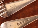 four forks and two spoons on a wooden table