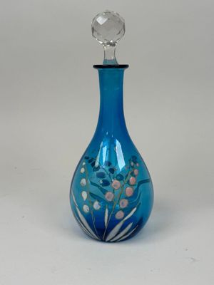 an image of a blue glass bottle with a flower design on it