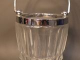 a clear glass bucket with a handle on a table