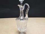 une photo d'un vase en verre transparent posé sur une table en bois