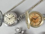 many different types of pocket watches on the table