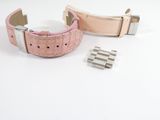 two pieces of pink leather with silver buckles on a white surface