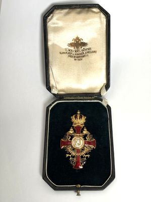 une image représentant une médaille dans un écrin posé sur une surface blanche