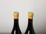 two bottles of wine sitting on top of a table next to each other