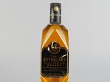 l'image d'une bouteille de whisky posée sur une surface blanche