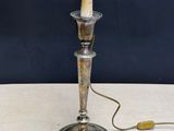 an antique silver plated candle holder with a wooden handle