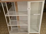 une armoire blanche avec des étagères, sur laquelle est posé un vase doré