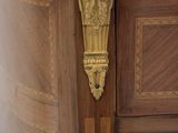 a wooden cabinet with a marble top and a gold handle