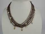 brown beaded necklace with silver leaf charms on a white mannequin