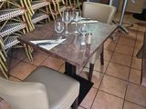 many chairs and tables in a restaurant with wine glasses on the table