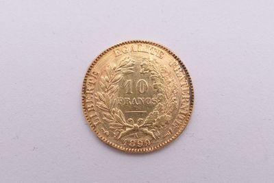 gros plan d'une pièce d'or sur une surface blanche