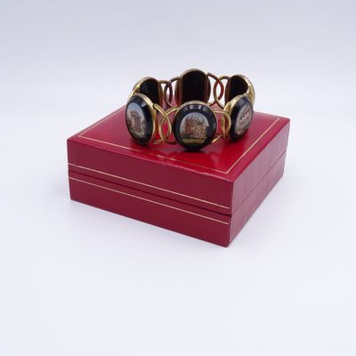 a red box with a bracelet on it on a white surface