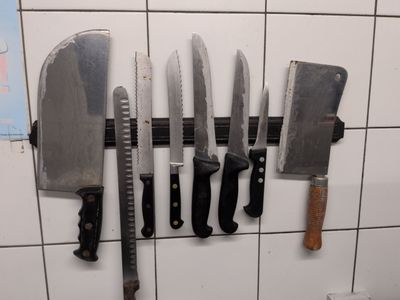 five knives hanging on a wall in a kitchen