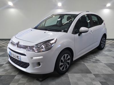 la petite voiture blanche est garée sur un sol en damier