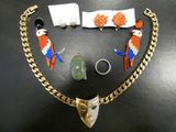 un collier, un bracelet, une bague et d'autres bijoux posés sur une table