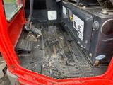 an image of a red truck with a suitcase in the back