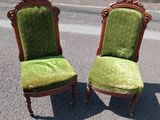 une paire de chaises recouvertes de velours vert, posées au bord de la route