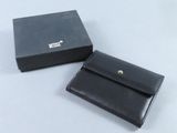 un portefeuille en cuir noir posé à côté d'une boîte noire
