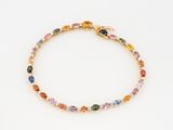 un gros plan sur un bracelet orné de pierres multicolores