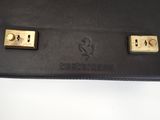 a close up of a black purse with two gold locks on it