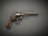 un gros plan d'un revolver posé sur une table, sur fond noir