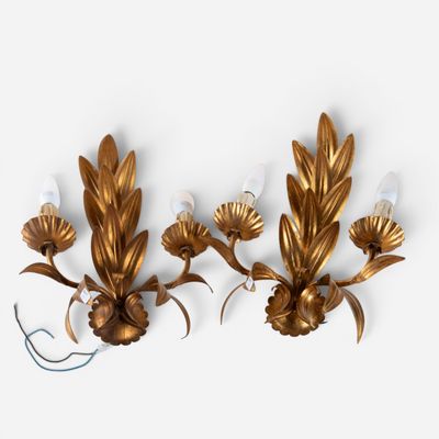 pair of gold leaf sconces on a white wall