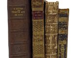 plusieurs vieux livres sont empilés sur une surface blanche