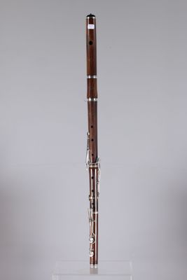 a close up of a wooden flute on a clear stand