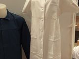 a mannequin in front of a dress on a mannequin stand