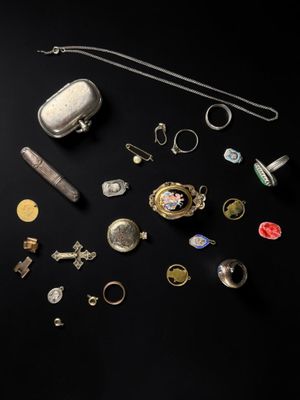 an assortment of silver and gold jewelry on a black background