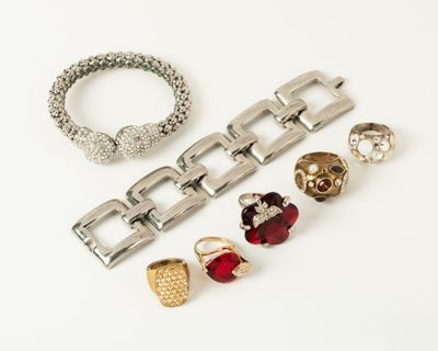 three pairs of rings and bracelets on a white surface